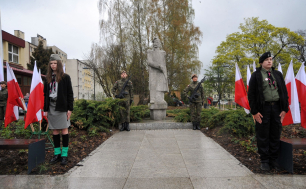 Na zdjęciu widzimy dwóch żołnierzy i dwóch harcerzy obok pomnika J.Kilińśkiego. Widać też zieleń miejską i polskie flagi.